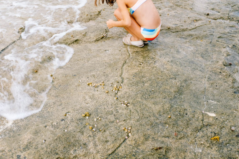 daughter looking at something on beach