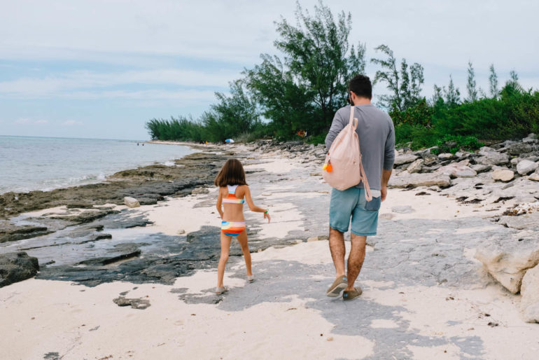 dad and daughter walking on beach