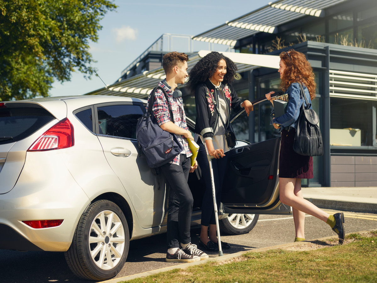 Young customers socialising by the car