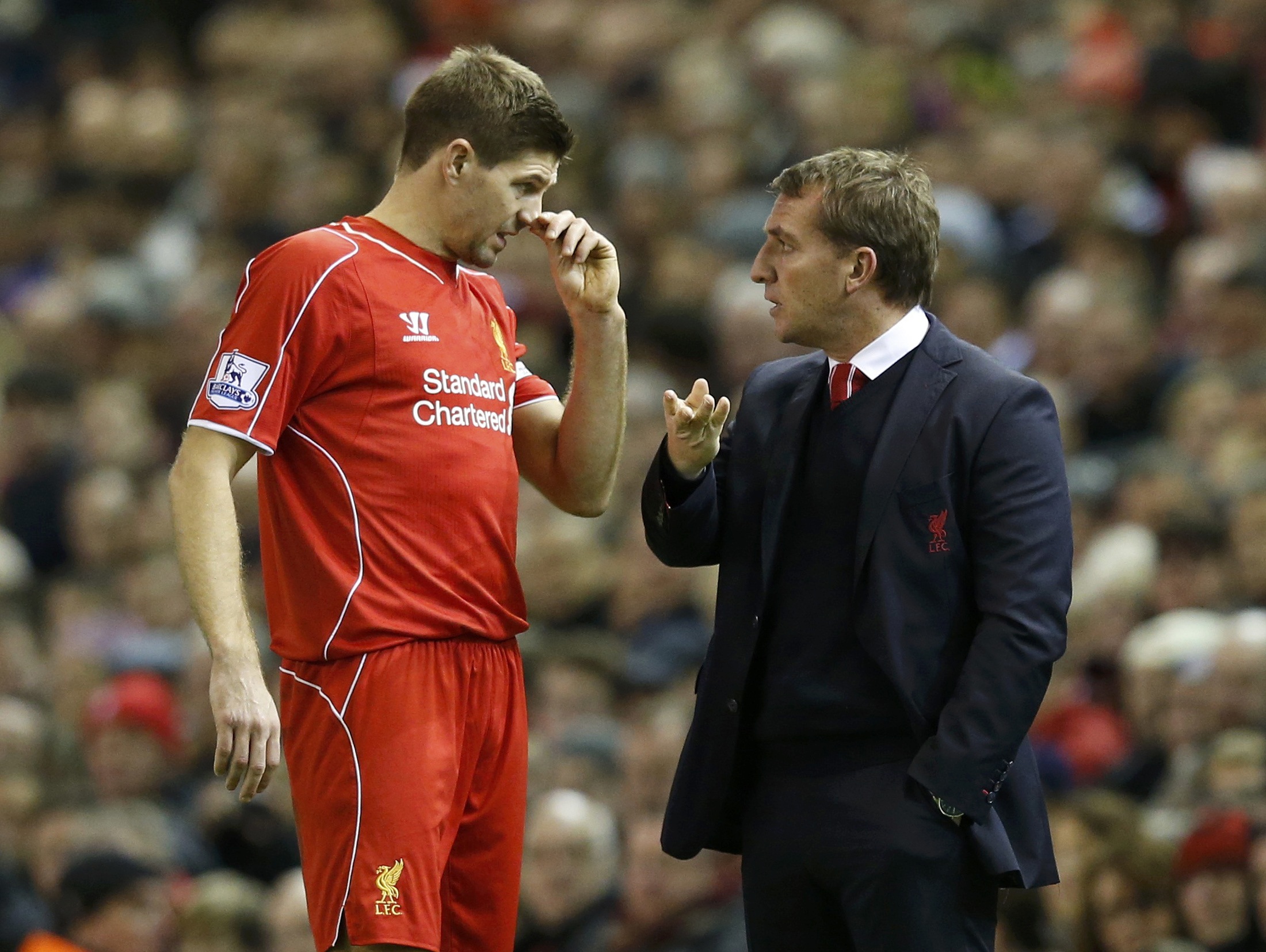 Liverpool manager Brendan Rodgers talks to Steven Gerrard during a break in their English Premier League soccer match against Arsenal at Anfield in Liverpool